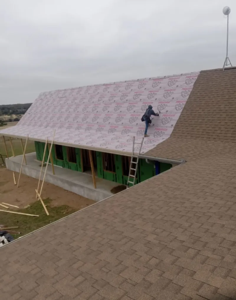 Worker preparing underlayment for a metal roof installation in Boulder City